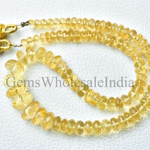 Peut inclure: Un brin de perles de citrine jaune, facettées et enfilées sur un fil. Les perles mesurent environ 6 mm de diamètre et ont une forme naturelle légèrement irrégulière. Le brin mesure environ 45 cm de long et est parfait pour la fabrication de bijoux.