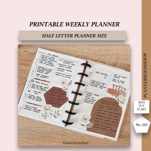 May include: A printable weekly planner in half letter size with black disc binding. The pages feature handwritten tasks, floral illustrations, and brown geometric shapes. Text includes PRINTABLE WEEKLY PLANNER, HALF LETTER PLANNER SIZE, PLANNERROOMSHOP, MON SUN START, and No_042.