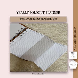Könnte beinhalten: Ein jährlicher Klappplaner im Format für persönliche Ringplaner. Der offene Planer zeigt ein Rasterlayout zur Planung. Der Text "YEARLY FOLDOUT PLANNER" und "PERSONAL RINGS PLANNER SIZE" sind sichtbar. Der Planer liegt auf einer strukturierten Oberfläche.