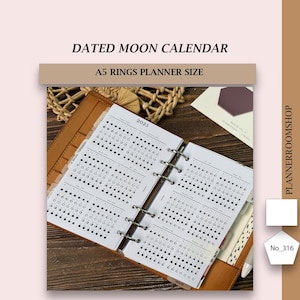 May include: A tan leather A5 rings planner containing white paper inserts with a 2025 dated moon calendar. The pages feature black printed lunar phase diagrams for each month of the year. The planner is open, showing metal binder rings.