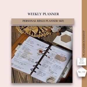 May include: Open weekly planner with handwritten notes, stickers, and floral accents. The planner is open to a spread with a list of tasks and appointments. The planner is brown and has a ring binder. The text "WEEKLY PLANNER" is at the top.