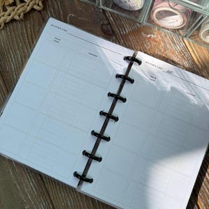 May include: A disc-bound planner insert featuring two white pages with black text and grid lines. The headers read DOCTOR'S VISIT and the number 200. Each page includes columns for date and reason, and treatment. The pages are held by black discs.