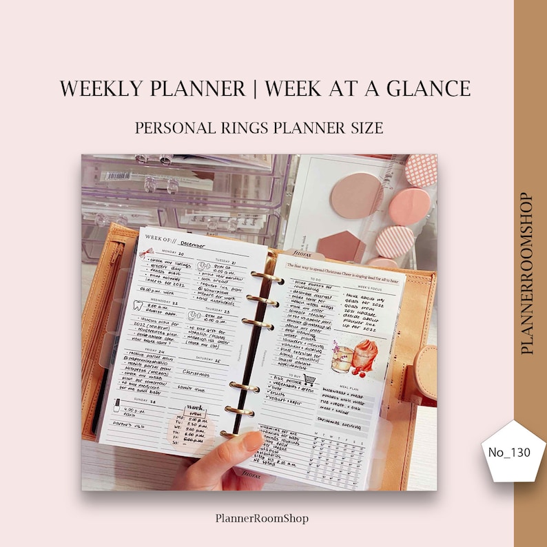 Op de afbeelding: Een weekplanner met een "Week in &eacute;&eacute;n oogopslag"-indeling in een persoonlijke maat. De planner is open voor de week van 12 december, met een hand die de pagina vasthoudt. De planner heeft een bruine leren omslag en gouden ringen.