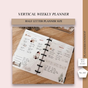 May include: A vertical weekly planner in half letter size with a white background and black grid lines. The planner has a black wire-o binding and is decorated with stickers and handwritten notes. The planner is open to a week view with the days of the week listed at the top of each column. The planner is also decorated with a small birdcage sticker and a small Christmas tree sticker.