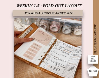 May include: A brown leather personal rings planner with a weekly 1.5 fold-out layout. The planner is open, revealing a detailed weekly schedule and various inserts. The image also shows decorative washi tape rolls and the text "WEEKLY 1.5 - FOLD OUT LAYOUT".