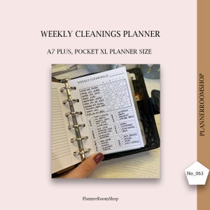Può includere: Un planner di pulizia settimanale in un planner nero di formato A7 plus. Il planner ha un elenco di attività di pulizia, tra cui lavare i piatti, pulire il fornello e aspirare. Il planner è aperto alla sezione di pulizia settimanale, con caselle di controllo per ogni giorno della settimana.