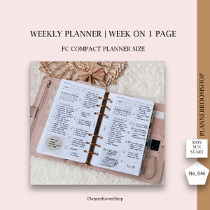 Puede incluir: Un planificador semanal con una semana en una página en formato compacto. El planificador está abierto para mostrar la semana y un calendario mensual. El planificador está en un archivador de cuero marrón con anillos dorados.