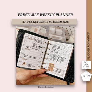 May include: A black leather A7 pocket planner with silver rings. The planner is open to a weekly spread with a to-do list, a daily log, and a notes section. The planner is decorated with stickers and handwritten notes.