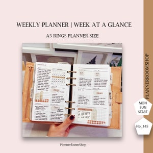 Peut inclure: Un agenda hebdomadaire avec une vue d'ensemble de la semaine. L'agenda est ouvert pour montrer un calendrier mensuel, une semaine et une section de notes. L'agenda est de taille A5 et a une couverture en cuir marron.