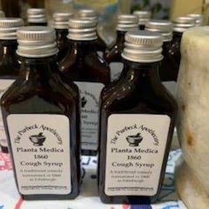 May include: Multiple small brown glass bottles with silver lids, each labelled "The Perfect Apothecary Planta Medica 1860 Cough Syrup A traditional remedy formulated in Edinburgh"