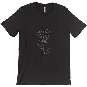 May include: Black t-shirt with a white line drawing of a rose on the front.