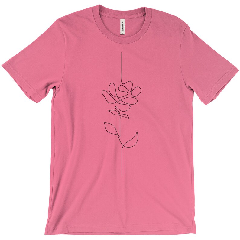 May include: A pink t-shirt featuring a single-line drawing of a rose on the front.