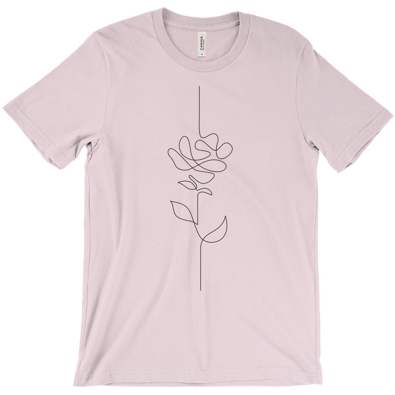 May include: A light pink t-shirt featuring a single-line drawing of a flower on the front.