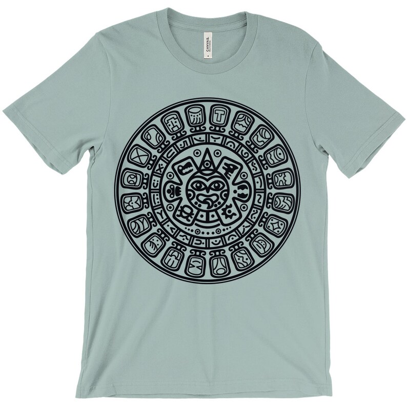 May include: A light blue t-shirt with a black graphic of the Aztec calendar, a circular design with glyphs and a central face.