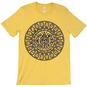 May include: A yellow t-shirt with a black graphic of the Aztec calendar. The calendar is a circular design with a central face and glyphs around the perimeter.