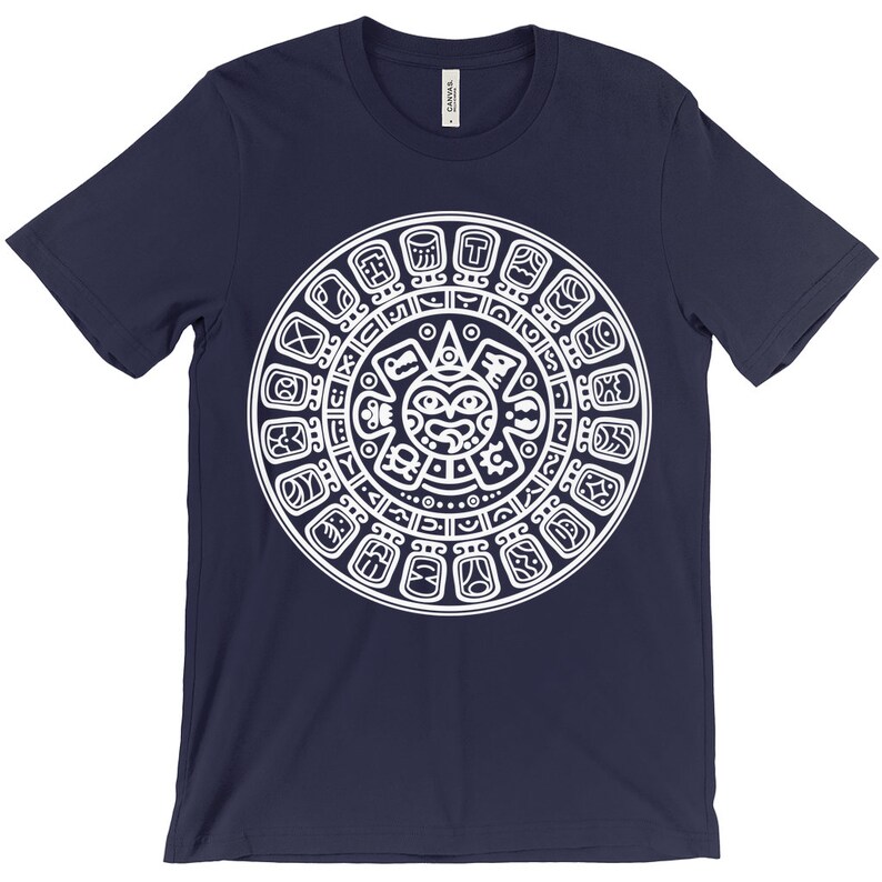 May include: A navy blue t-shirt with a white graphic of the Aztec calendar. The calendar is a circular design with a central sun face and glyphs around the perimeter.