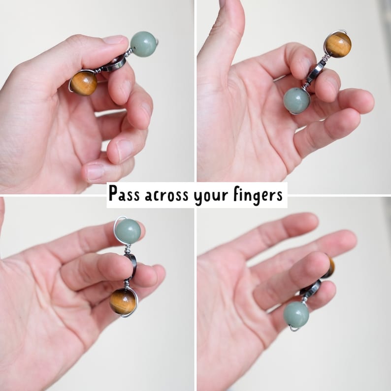 May include: A hand holding a beaded fidget toy with green and brown beads. The beads are connected by silver wire and a silver ring. The text "Pass across your fingers" is visible below the hand.