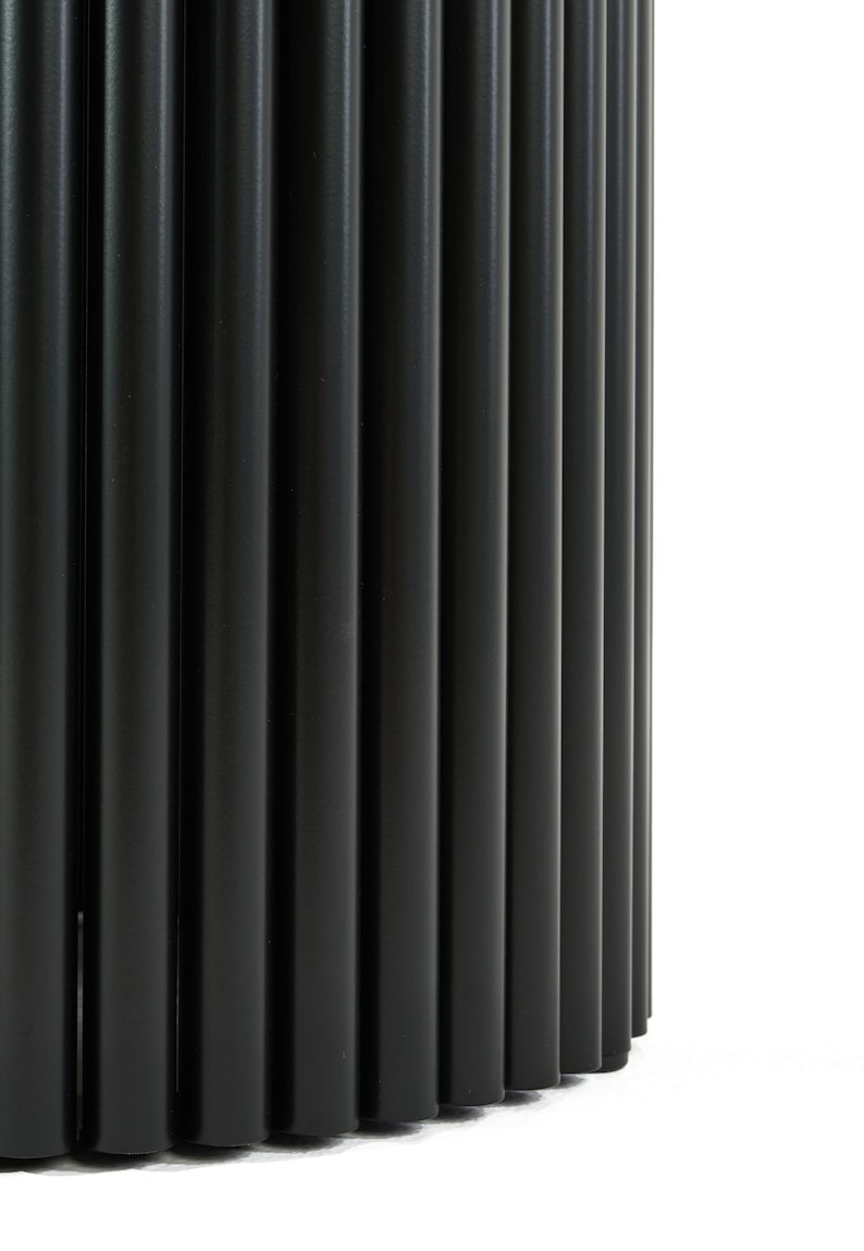 May include: A black metal table base with a cylindrical shape and a fluted design. The base is made of multiple vertical metal rods.