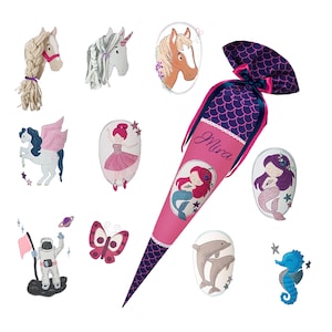 Könnte beinhalten: Ein rosa-blauer Schultüte mit dem Namen "Mira" darauf. Die Tüte ist mit einer Meerjungfrau, einem Einhorn, einem Schmetterling, einem Seestern, einer Muschel und einem Delfin verziert.