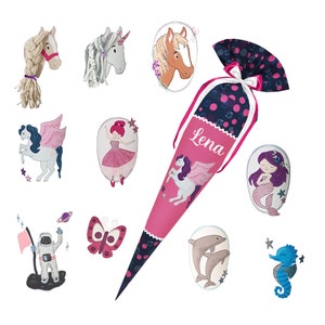 May include: A pink and blue school cone with the name "Lena" embroidered on it. The cone is decorated with various embroidered images, including a unicorn, a mermaid, a butterfly, a seahorse, and a ballerina.