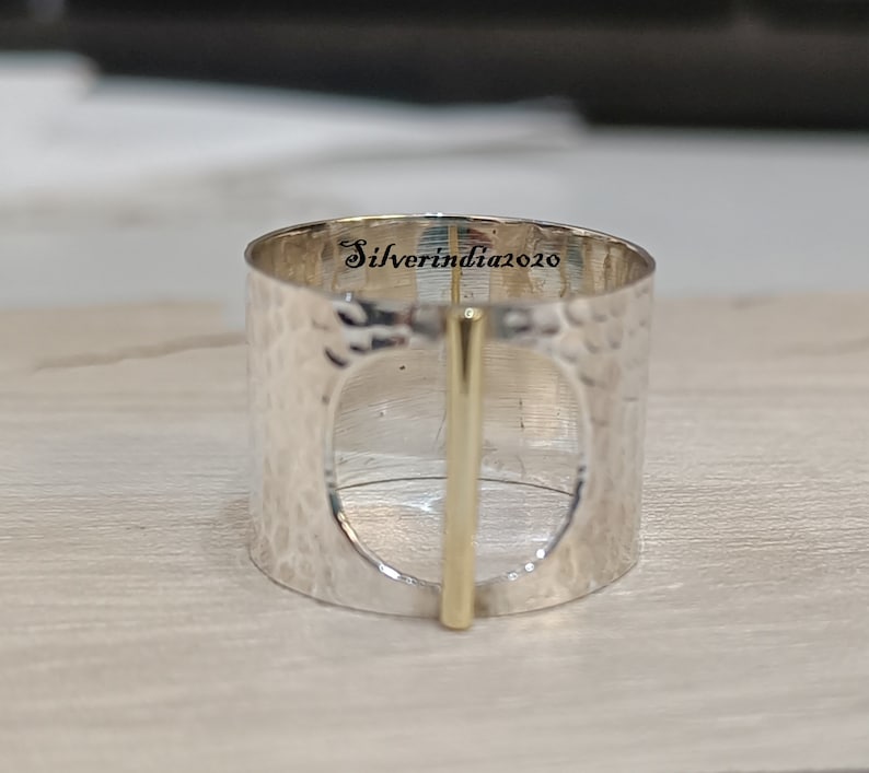 Puede incluir: Anillo de plata con textura martillada y un acento de barra de oro. El anillo est&aacute; inscrito con "Silverindia2020".