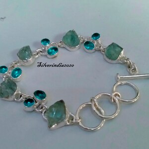 Puede incluir: Pulsera de plata con cierre de palanca. La pulsera presenta piedras preciosas de color azul claro y azul oscuro.