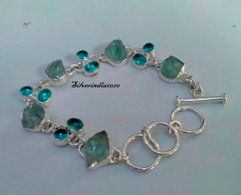 Puede incluir: Pulsera de plata con cierre de palanca. La pulsera presenta piedras preciosas de color azul claro y azul oscuro.