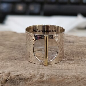 Puede incluir: Anillo de plata con textura martillada y una barra de oro en el centro. El anillo tiene un c&iacute;rculo grande abierto en el centro. El anillo est&aacute; grabado con el texto "Silverindia2020".