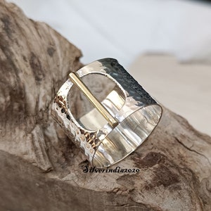 Puede incluir: Un anillo de plata con textura martillada y un acento de barra de oro. El anillo es ancho y tiene un dise&ntilde;o &uacute;nico.