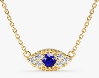 Può includere: Una collana con catena d'oro con un ciondolo a forma di occhio in zaffiro blu e diamanti.