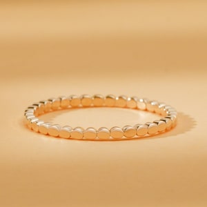 May include: A gold ring with a beaded design. The ring is made of small, round beads that are evenly spaced.