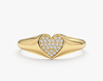 Könnte beinhalten: Ein goldener Ring mit einem herzförmigen Design, das mit kleinen Diamanten besetzt ist.