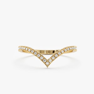 Puede incluir: Un delicado anillo de banda de oro con un diseño en forma de V engastado con pequeños diamantes.