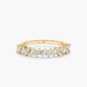 May include: A gold band ring with a row of small, baguette-shaped diamonds set in a staggered pattern.