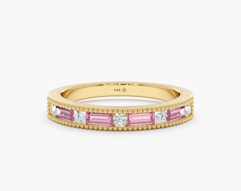 Könnte beinhalten: Ein Goldring mit einer Reihe von rosafarbenen und weißen Edelsteinen. Der Ring hat einen zarten Milgrain-Rand.