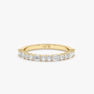 Puede incluir: Un anillo de banda de oro con piedras preciosas claras redondas y de corte baguette alternadas. El anillo está engastado con múltiples piedras preciosas y tiene un acabado pulido. El anillo está marcado con "14K".