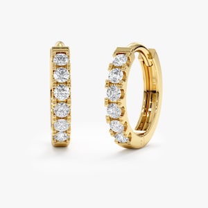 May include: A pair of gold hoop earrings with a row of clear round diamonds set in the band.