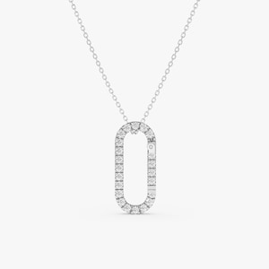 May include: A silver chain necklace with a diamond-encrusted oval pendant. The pendant is shaped like a sideways 'O' with a small diamond in the center.