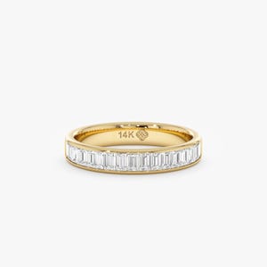 May include: A gold band ring set with rectangular-cut diamonds. The ring is crafted from 14K gold and showcases a refined design. The diamonds are closely set, producing a continuous sparkle. A timeless piece of jewellery.