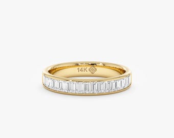 Pode incluir: Um anel de banda dourado com diamantes de corte retangular. O anel é feito de ouro 14K e apresenta um design delicado. Os diamantes são colocados próximos uns dos outros, criando um brilho contínuo. Uma joia clássica.