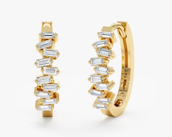 Puede incluir: Un par de pendientes de aro de oro con una fila de diamantes talla baguette dispuestos en forma escalonada.