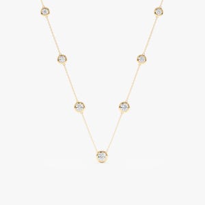 May include: A gold chain necklace with seven bezel-set round diamonds.
