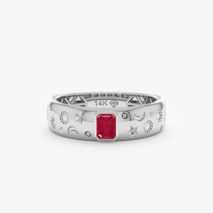 Op de afbeelding: Een zilverkleurige bandring met een centrale, smaragdgeslepen rode edelsteen, versierd met gegraveerde ster- en maansikkelmotieven en kleine ingelegde ronde steentjes. De binnenkant van de ring is duidelijk gestempeld met de tekst 14K.