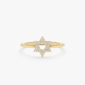 Op de afbeelding: Een gouden ring met een Davidster-ontwerp. De ster is bezet met kleine, sprankelende diamanten. De ringband is van effen goud. De ring wordt getoond tegen een witte achtergrond. Een elegant en symbolisch sieraad.