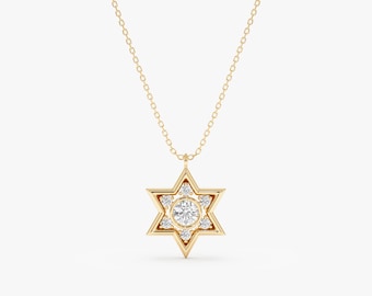 May include: A gold-colored necklace featuring a Star of David pendant. The pendant has a central, round, clear gemstone surrounded by six smaller gemstones. The necklace chain is also gold-colored.