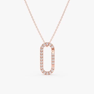 May include: A rose gold necklace with a diamond-encrusted oval pendant. The pendant is shaped like a clasp.