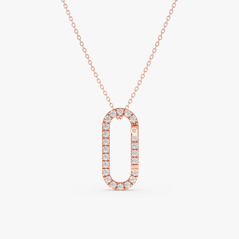 May include: A rose gold necklace with a diamond-encrusted oval pendant. The pendant is shaped like a clasp.