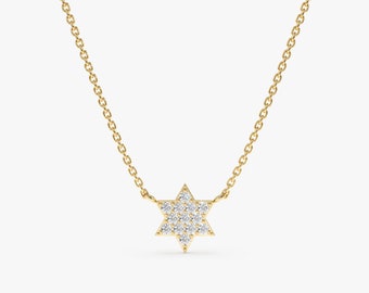 May include: A delicate gold necklace featuring a Star of David pendant. The pendant is encrusted with small, sparkling diamonds. The necklace has a fine chain and is displayed against a neutral background.