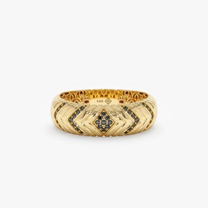 May include: A gold band ring with a chevron pattern set with black diamonds. The ring is marked "14K" on the inside.