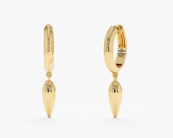 May include: A pair of gold hoop earrings with a teardrop-shaped charm. The earrings are made of polished gold and feature a hinged closure. The charm is a smooth, elongated teardrop shape. The earrings are displayed against a white background.